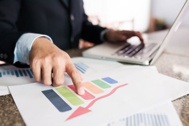 a man in a business suit pointing at a chart.